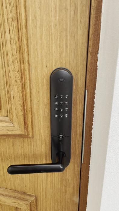 En person trycker på en digital knappsatslås på en dörr.