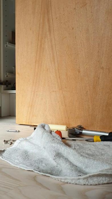 En person demonterar en elektronisk anordning och avlägsnar tejp från en trådig och smutsig yta.