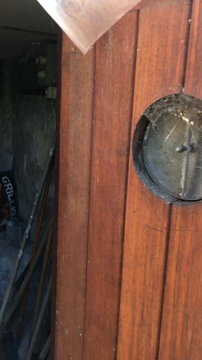 Verktygshörn med sopkvastar, grepar, och en spade lutade mot en stenvägg. Filmen är suddig och tagen i en vinkel.