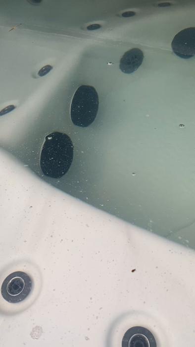 Det är en film av en spa-badkar eller bubbelpool, delvis fylld med vatten och utrustad med jetmunstycken, sett uppifrån.