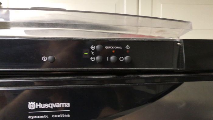 En person trycker på en knapp märkt "QUICK CHILL" på en apparats kontrollpanel.