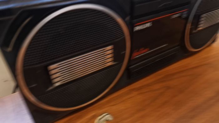 En gammal Philips radio, modell D8040, svart, med kassettspelare, på ett träbord.