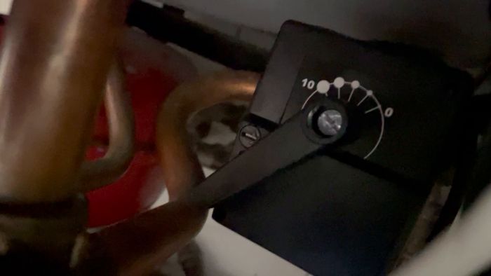 En suddig film visar någons hand som justerar en kontroll med vita markeringar, möjligen en del av en maskin eller elektronisk utrustning.