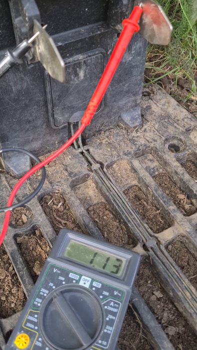En multimeter visar 3.9V bredvid jord och en svart låda med ansluten röd kabel och metallblad.