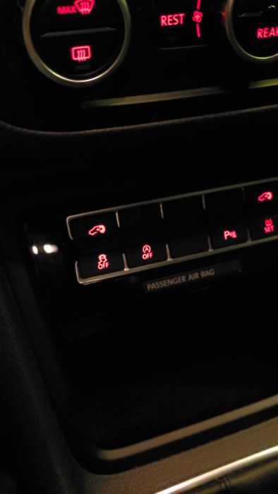 Film från bilens instrumentpanel på natten med upplysta knappar och symboler, inklusive passagerarairbag-indikator.