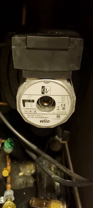 En cirkulationspump från WILO med teknisk information på en etikett, kablar och rör i bakgrunden.