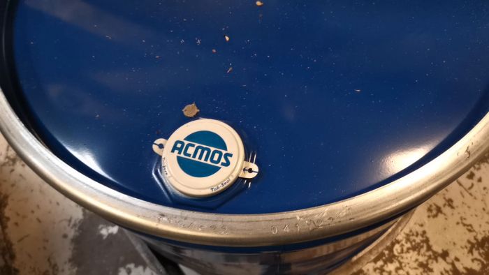 En burklock som snurrar på en blå yta med smuts och smulor runtomkring. Snurrande rörelse visar rörelseoskärpa.