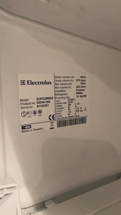 Det är en informationsetikett på en Electrolux-frys som visar modell, volym, kylmedel, energiklass, och serienummer. Made in Sweden.