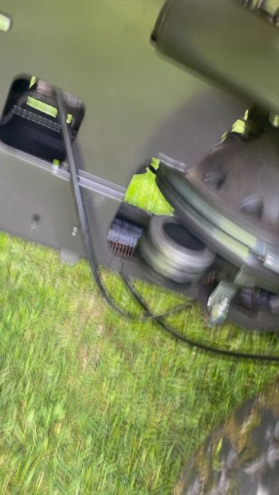 Film som visar en gräsklippare med löst sittande rem som orsakar oväsen när klippaggregatet fälls ner. Ägaren söker hjälp för att lösa ljudproblemet.