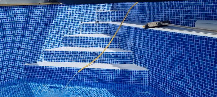 Se kakelarbetet som utförs i denna poolbyggnadsprocess, med detaljbilder på det blå mosaikkaklet och arbetets framsteg.
