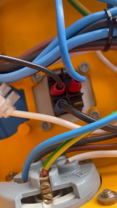En kort video som visar en närbild av kablar i en gul elbox. Diskussionen handlar om att identifiera om de vita kablarna används för strömförsörjning till en manick. Tack för all hjälp och input!