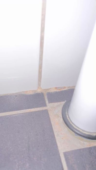 Upptäck hur små hål i fogen i ett badrum kan leda till fuktproblem. Filmen visar områden med skador bakom handfatet och nära duschen. Diskutera möjliga orsaker och lösningar för att undvika framtida skador. Idealisk för hemmafixare och renoverare som söker råd.