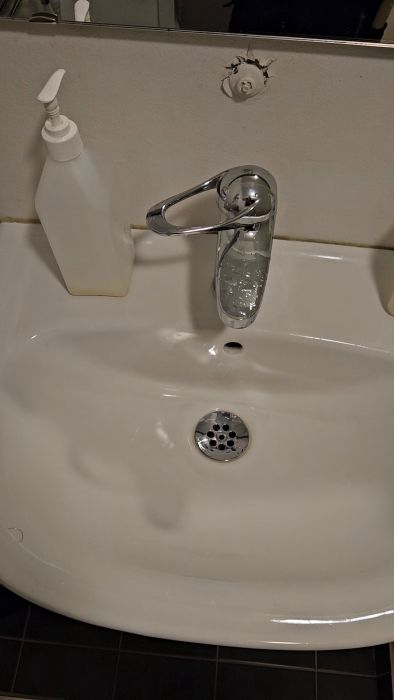 En frustrerande situation visas när en pappershanddukshållare krånglar och orsakar irritation. Användarens insats betonas med texten 'Vansinne!' och speglar de problem som uppstår i vardagliga uppgifter.