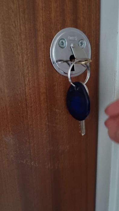 Videon visar ett låsproblem där nyckeln fastnar i överlåset. Trots att låsning och upplåsning fungerar, går nyckeln inte att ta ut. Frågan är om det krävs en låssmed för att åtgärda problemet, med låset och nyckeln märkta 'FAS'.