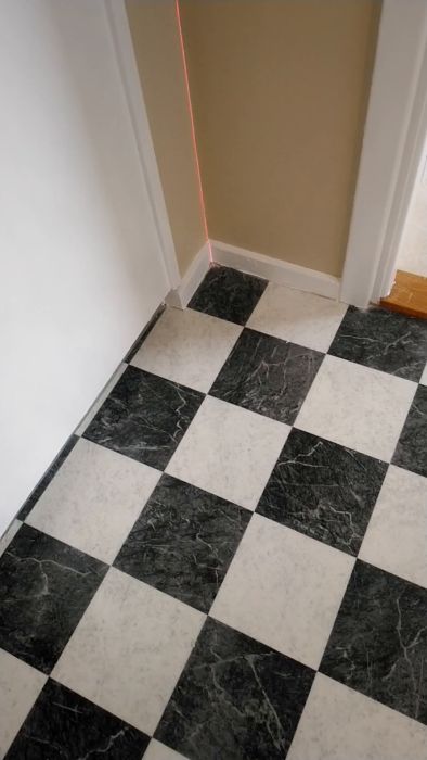 Upptäck hur en laser används för att justera och kontrollera vinklar i hörnet längst åt vänster i rummet. Tekniken illustrerar hur precision uppnås i byggprojekt. Perfekt för både proffs och hemmafixare som vill förbättra sina färdigheter.