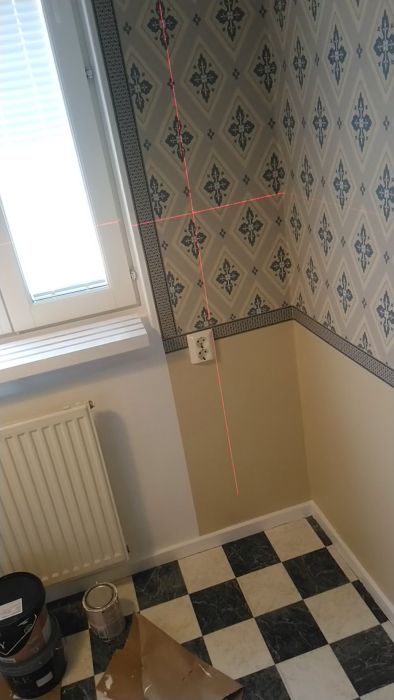 Upptäck tekniker för att justera tapetmönster vid sidan av ett fönster. Videon visar laserjustering för att få rätt lutning, med fokus på hur mönstret kan anpassas för att ge ett enhetligt utseende utan feljusteringar.