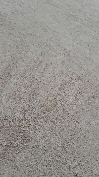 Filmen visar ett betonggolv som blivit svagt och mjölar sig vid skrapning med tumstock. Frågan är vad som orsakat problemet och hur det kan lösas för att möjliggöra klinkning av golvet.