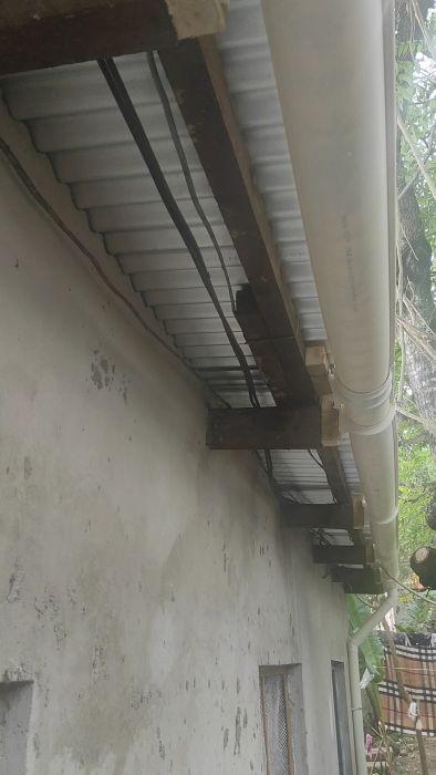 Se hur nätbolagets elanslutning har installerats till bostaden i Dar es Salaam. Anslutningspunkten är lättåtkomlig från marken, vilket kan underlätta vid framtida underhåll eller inspektioner.