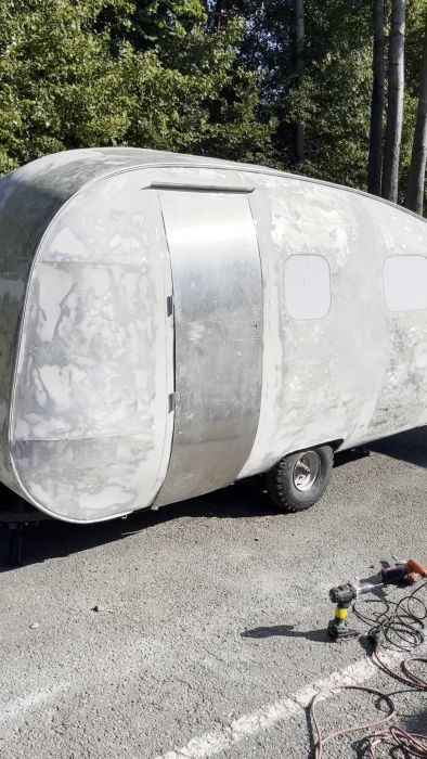 Se processen för att montera en dörr genom att justera aluminiumkanter och förstärka strukturen med epoxi och mikroballonger för gångjärn och lås. Resultatet: en säkert låsbar dörr som möjliggör lagring av verktyg och material.