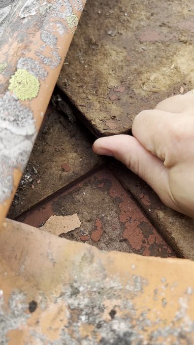 En genomgång av taket på ett sommarhus från 1800-talet där gamla masonit-diamanter byts ut. Diskussion om att använda underlagspapp eller oljehärdad board och om möjliga justeringar av läktavståndet för optimal takläggning.