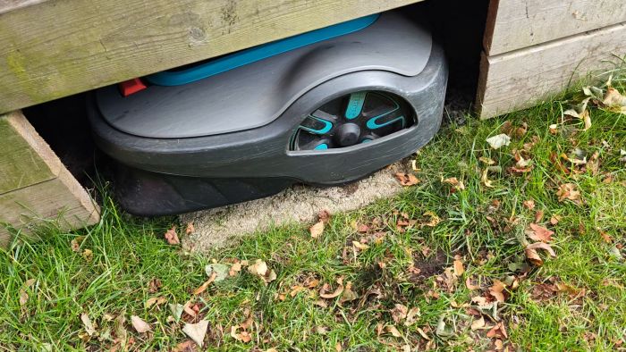 Robotgräsklipparen dockar snett, möjligen på grund av feljusterad guidekabel eller ojämn platta. Diskutera lösningar och justeringar för att förbättra dockningen och undvik framtida problem.