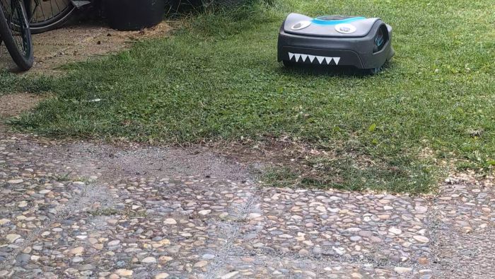 En gräsklippare gör oförutsedda skarpa svängar mot guiden, speciellt i svaga ytterkurvor och vid övergång till plattor. Filmen visar området och klipparens rörelser, inklusive problem med mappning och kalibrering.