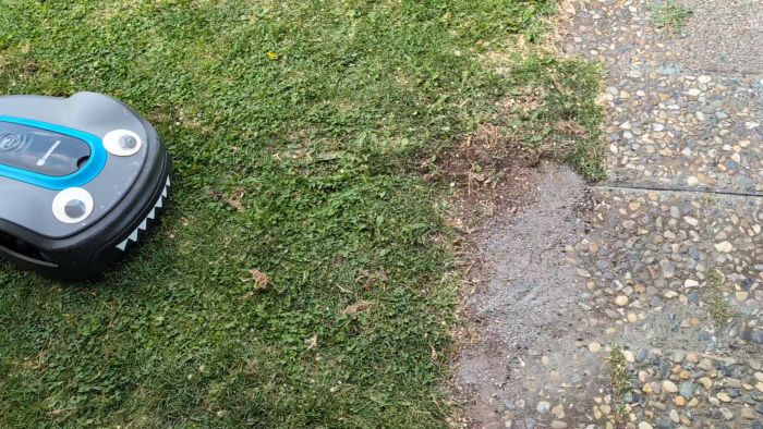 Filmen visar en robotgräsklippare som följer guidekabeln men stannar när vänster hjul korsar den. Trots justeringar av kabelns längd enligt supportens råd kvarstår problemet. Händelsen inträffar inte under kalibrering, vilket gör felsökningen komplex.