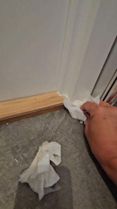 En video som visar potentiella problem i ett nyrenoverat badrum där vatten rinner mot tröskeln och fogar inte verkar täta. Frågor ställs kring behovet av en oberoende besiktningsman för att säkerställa kvaliteten på renoveringen.