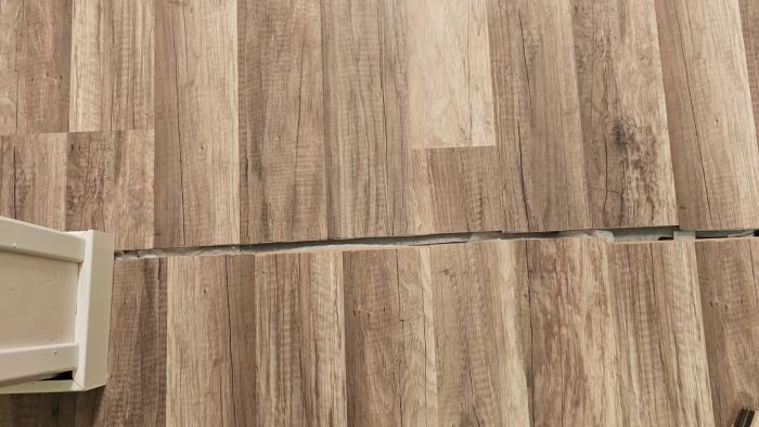 Se hur en extra remsa skum används för att jämna ut höjdskillnaden mellan två golvytor. Det flexibla golvet rör sig mycket vid dörrspringan, och en självhäftande list planeras för att öka stabiliteten. Utforska lösningar och problem vid golvläggning.