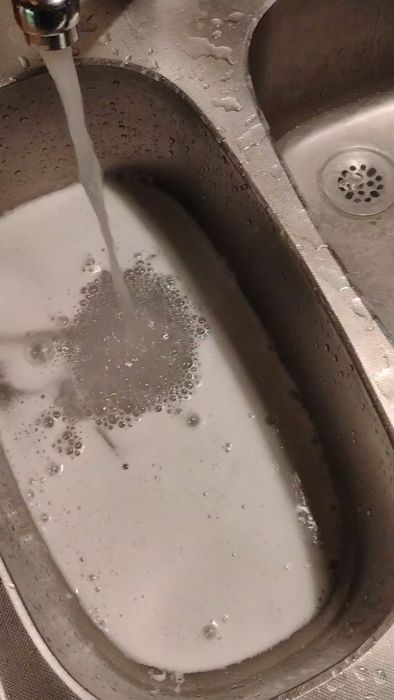 En video som visar dålig avrinning i köksavloppet. Två diskhoar fylls snabbt när vatten spolas, men avrinningen förbättras markant när gallret och röret tas bort. Utforskar potentiella orsaker till problemet.