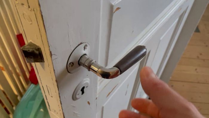 Se hur problemet med ett vingligt dörrhandtag i ett sekelskifteshus analyseras. Dörrens låshus sitter fast, men handtaget verkar löst på grund av en tunn stav.