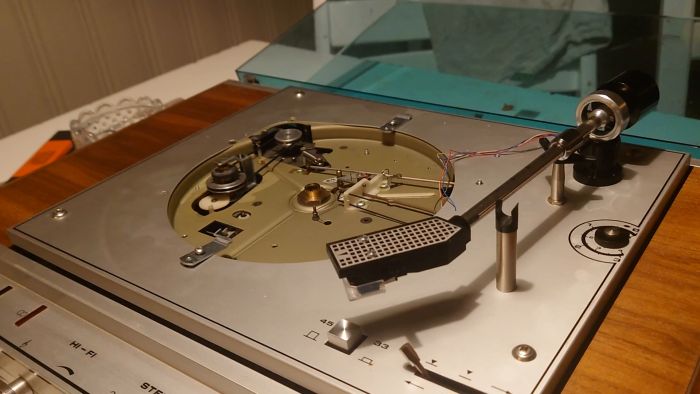 Följ processen när en gammal skivspelare får nytt liv genom rengöring och reparation av en trög tonarm. Utmaningar som att löda kablar återstår, men framstegen är tydliga när spelaren nu fungerar igen.