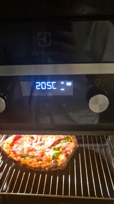 Se hur ugnen visar en symbol på displayen vid 205°C samtidigt som ett pip ljuder. Perfekt för att förstå hur din ugn fungerar och vad symbolerna betyder under användning.