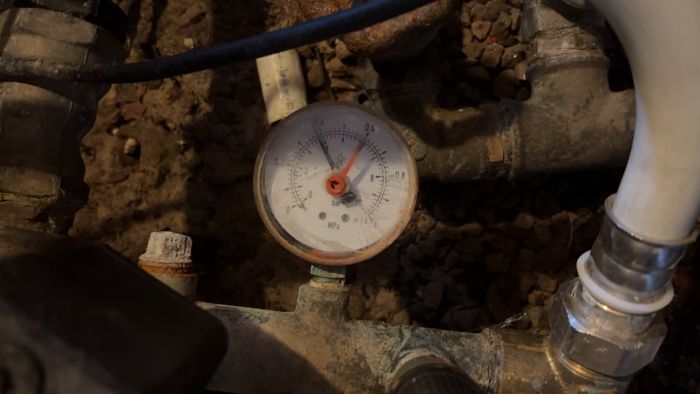 Se hur trycket varierar i vårt vattenledningssystem varje gång det knäpper i elcentralen. Vi har haft problem med lågt tryck och använder en kompressor för att nå rekommenderade 2,7 bar. Behöver råd om manometern och dess avläsning.