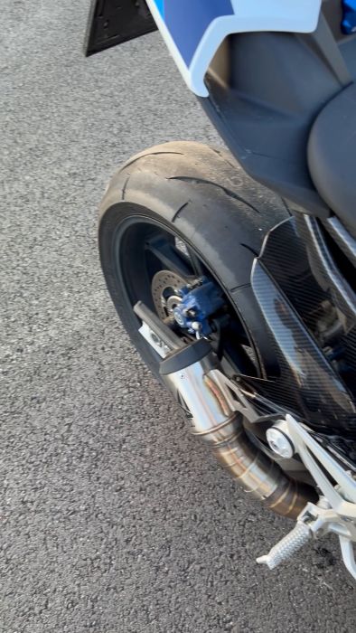 En närbild på bakhjulet och bromssystemet på en motorcykel. Filmen ger detaljerad insyn i däckets mönster och bromsarnas funktion. Perfekt för de som gillar motorcykelunderhåll och prestandadiskussioner.